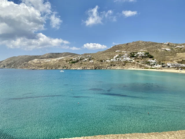 Turquoise water and hillside buildings around Kalo Livadi Bay in May 2023