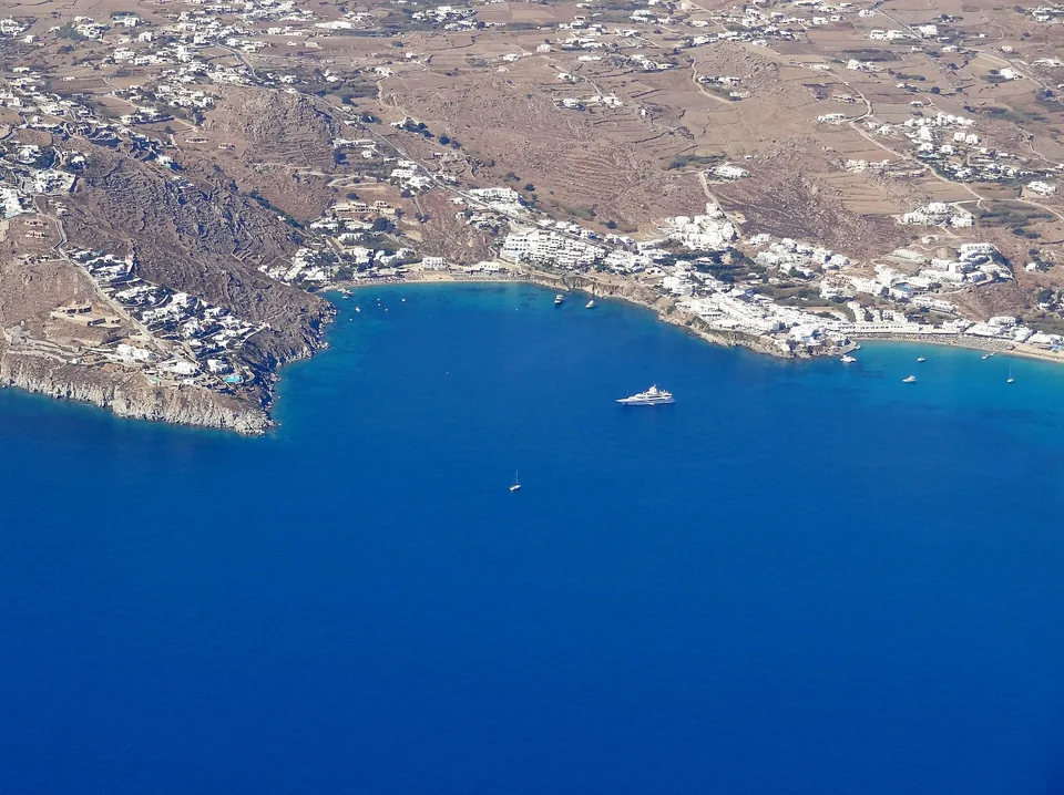Aerial view of Psarou Bay, its beach and the surrounding Mykonos hillside